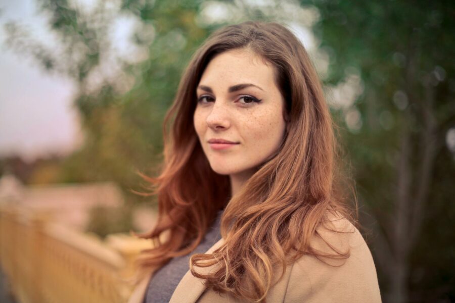 closeup photo of woman with brown coat and gray top