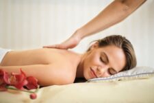 topless woman lying on bed getting massage